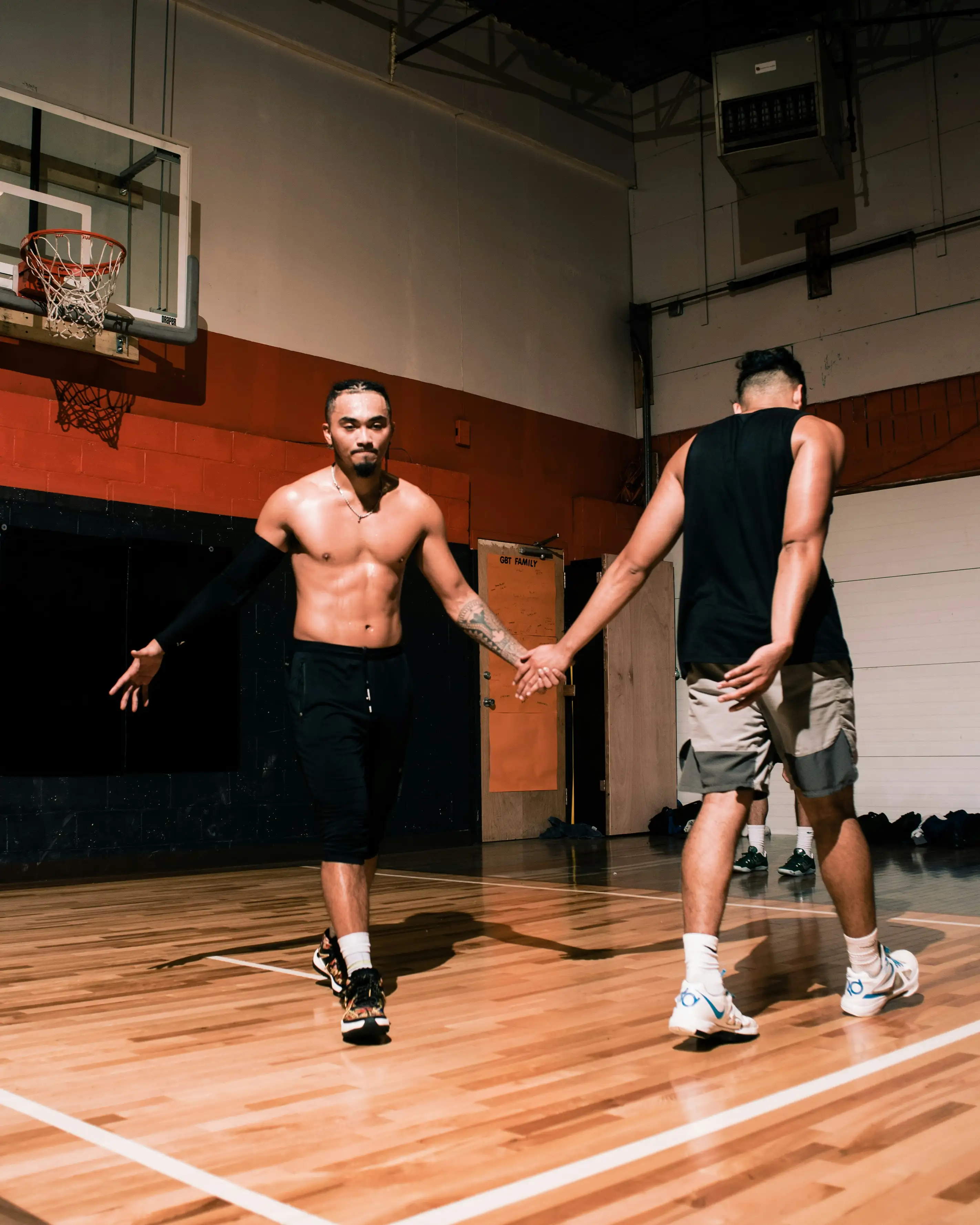 Friends playing basketball together in a gym